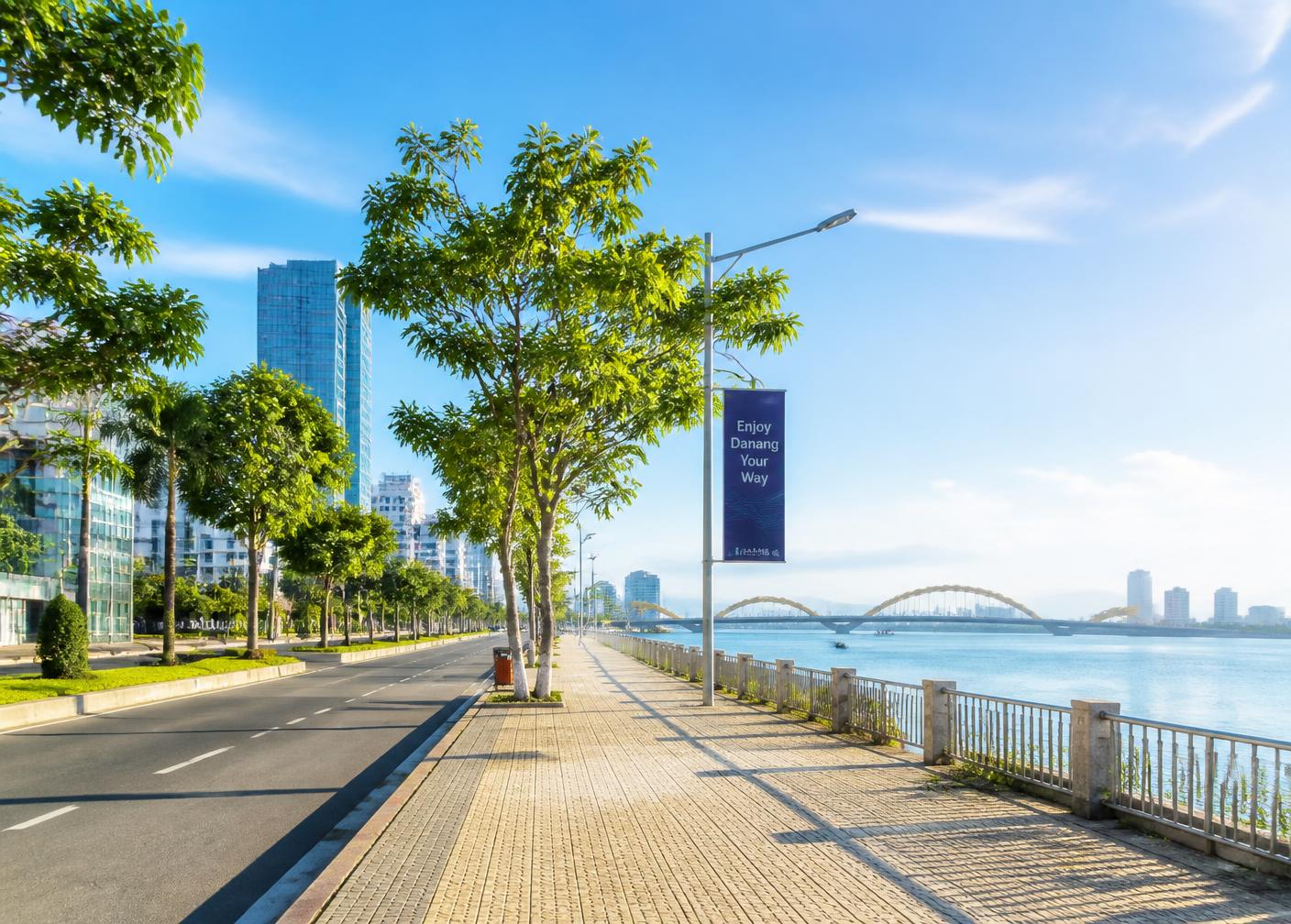 A bright, tree-lined riverside boulevard in Da Nang on a clear day